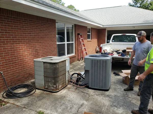 Old and new outdoor AC units side by side on installation day
