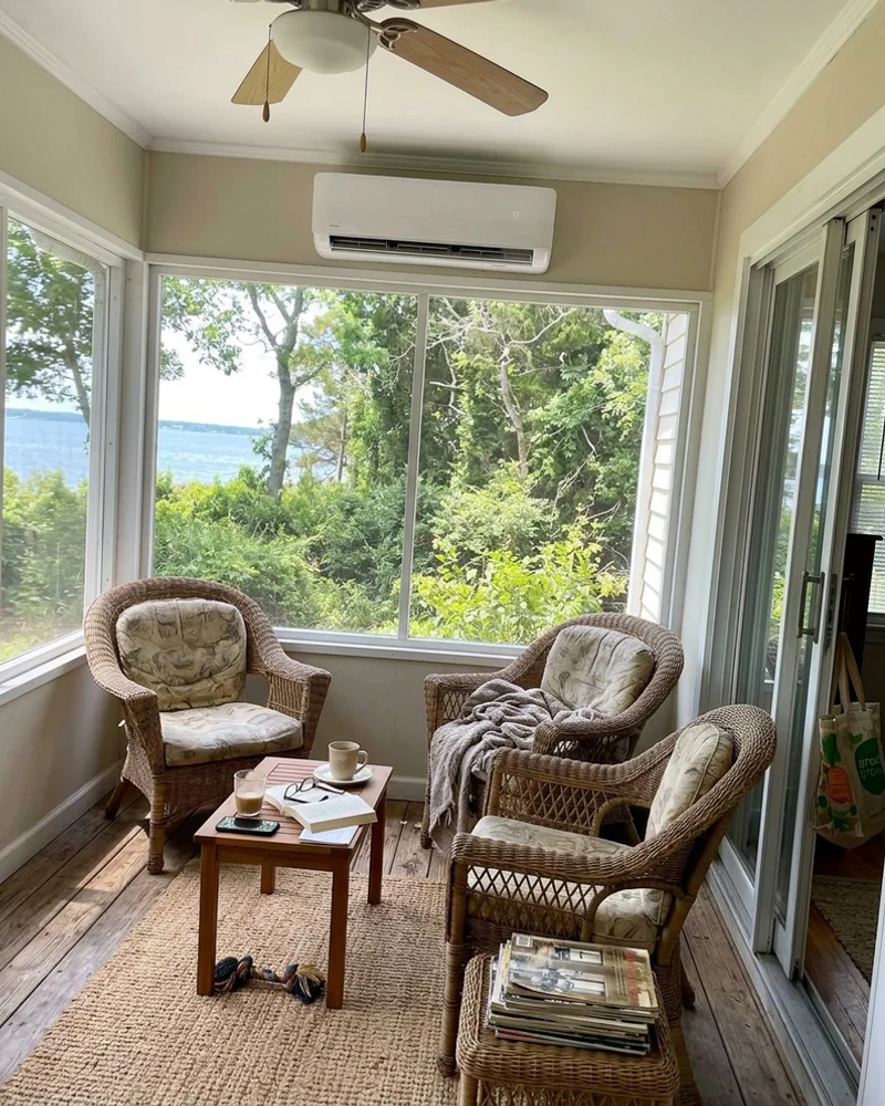 Wall-mounted ductless mini-split in a bright sunroom with wicker chairs