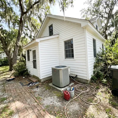 Illustration of a coastal Eastern Shore home with an outdoor AC condenser under live oaks